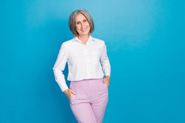 Sticker - Photo of positive corporate director lady put hands pockets posing empty space isolated on blue color background