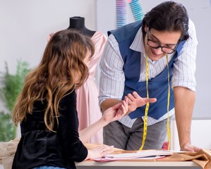 Wall Mural - Young male tailor teaching female student