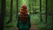 © Maksym - woman with long red hair in a green dress stands with her back in the forest