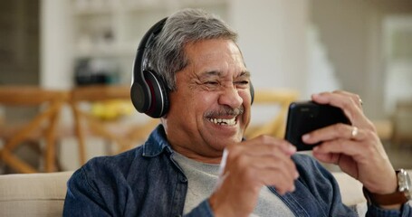 Canvas Print - Laughing, senior man and a movie on a phone, watching a funy video or film on the internet. Happy, streaming and an elderly person with headphones, mobile and a comedy show on an app on the home sofa