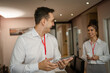 © Miljan Živković - Young couple man and woman standing in hotel room talk about business