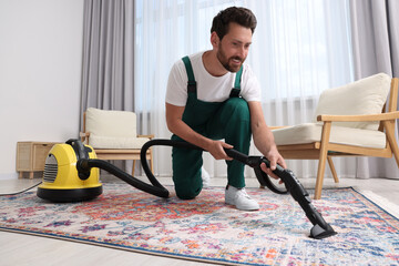 Wall Mural - Dry cleaner's employee hoovering carpet with vacuum cleaner in room