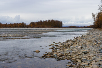 Wall Mural - View from the shore to the river. Autumn landscape. Beautiful nature of Siberia and the Russian Far East. Travel and tourism in the Magadan region. Russia.