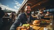 A happy man eating a burger in an outdoor restaurant as a Breakfast