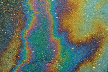 Gasoline That Had Leaked Onto A Wet Parking Lot Creates A Rainbow Oil Slick