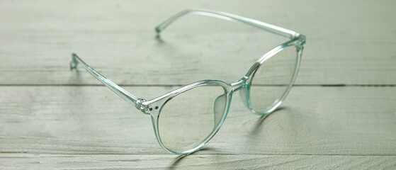 Stylish eyeglasses on green wooden background