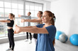 © Pixel-Shot - Sporty young woman training with group in gym