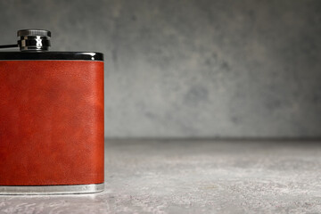 New hip flask on grunge background, closeup