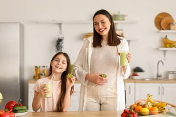 Sticker - Little girl with her pregnant mother drinking green smoothie in kitchen