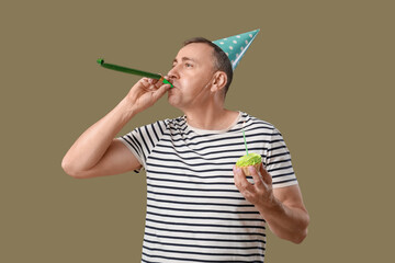 Poster - Mature man with party blower and birthday tartlet on green background