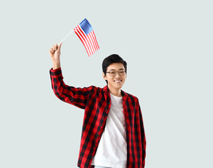 Sticker - Young Asian man with USA flag on light background