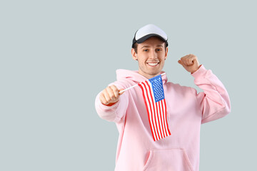 Wall Mural - Happy young man with USA flag on light background