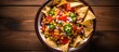 Top view of a bowl filled with Mexican vegetable salad cowboy caviar and nachos on the table With copyspace for text