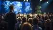 © Planetz - A man is giving a speech on stage during a seminar bussines. Business and entrepreneurship symposium.  Audience in the conference hall A lot of people in the blurred background