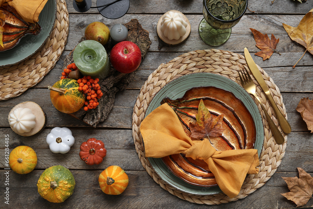 Autumn table serving with pumpkins and dry leaves on grey wooden table