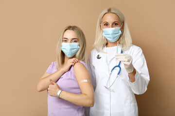 Canvas Print - Doctor and young woman after vaccination on beige background