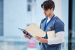 © Rene L/peopleimages.com - Hospital folder, doctor and man reading documents, healthcare records or clinic information. Wellness services, medical research and professional nurse, surgeon or expert check paperwork portfolio