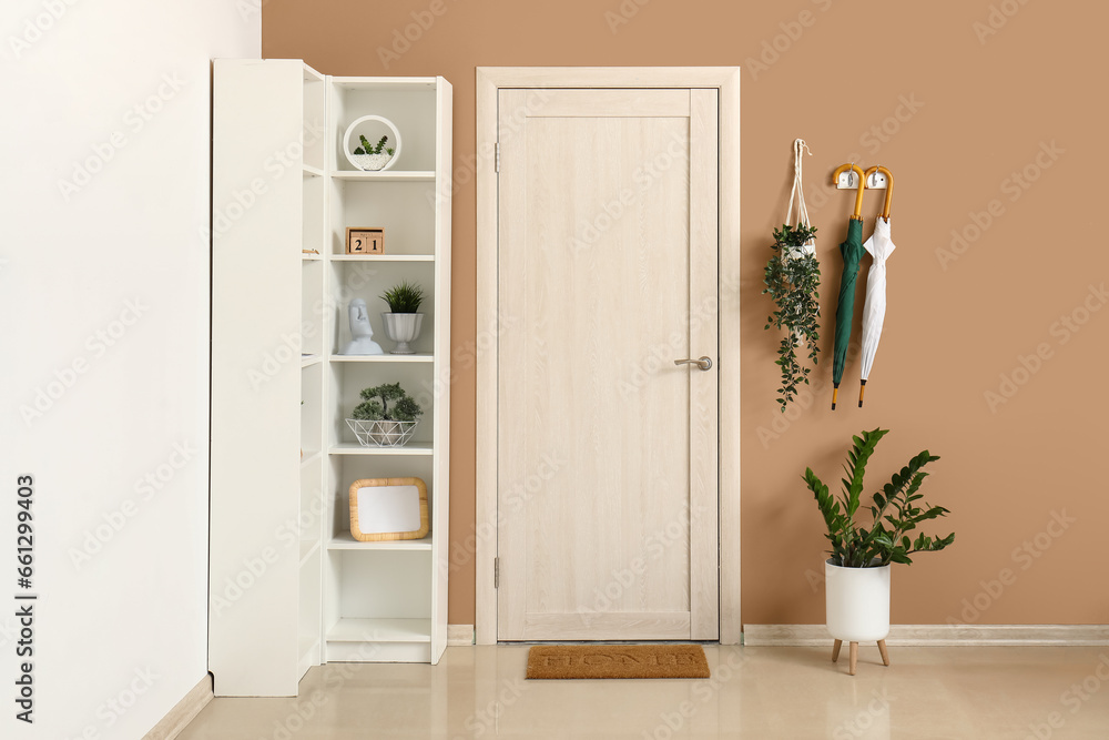 Umbrellas and houseplants in interior of hallway