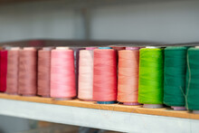 Row of multicolored thread spools at sewing factory