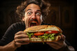 Portrait of a man eating a big sandwich