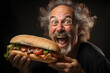 Portrait of a man eating a big sandwich