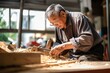 An elderly carpenter in retirement age repairs wood products
