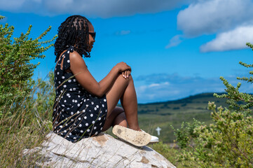 Poster - Woman seen sitting on a rock