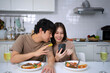 © Suney - Young couple is shopping online in kitchen.