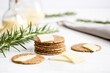 rye crackers with asiago cheese and rosemary sprig on a white table