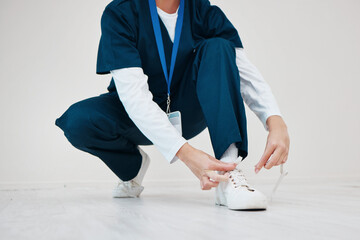 Canvas Print - Healthcare, shoes and tie with hands of a nurse in studio while getting ready for medical service closeup. Medical, lace and dressing with a medicine professional in uniform at a clinic for nursing