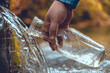 Close-up of a man collecting spring water into a transparent bottle A beautiful natural source of clean drinking water. A hand holds a bottle under a stream of cool water drawing it to quench thirst.
