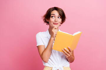 Poster - Portrait of smart young lady touch chin learning in university reading literature book looking minded isolated on pink color background