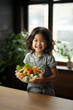 Enfant asiatique souriant qui mange un repas sain et équilibré.