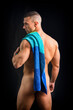 © theartofphoto - A shirtless man with a towel on his shoulder, covering his buttock. Portrait of naked handsome young man with languishing look covering crotch with a towel, against dark background