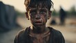 Closeup of a ghetto boy, a starving orphan in a war refugee camp. With a sad expression and clothes and eyes filled with pain