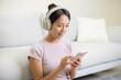 Woman wear headphone and use of mobile phone at home