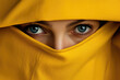 A woman's piercing blue eyes peek out from behind a vibrant yellow hijab, framing her human face and adding a touch of mystery to her person