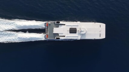 Wall Mural - aerial top down tracking view of a catamaran jet passenger ferry boat traveling with high speed over