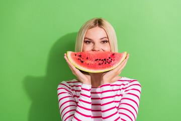 Wall Mural - Photo of cheerful nice girlish woman with bob hairstyle wear striped shirt hold watermelon on mouth isolated on green color background