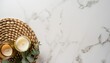 Top view candles on rattan serving mat with eucalyptus on white marble background