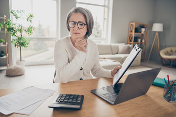 Canvas Print - Photo of confident clever senior lady boss dressed white cardigan counting payment modern gadget indoors house room