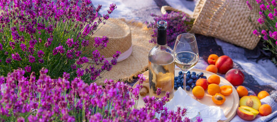 Wall Mural - wine, fruits, berries, cheese, glasses picnic in lavender field Selective focus