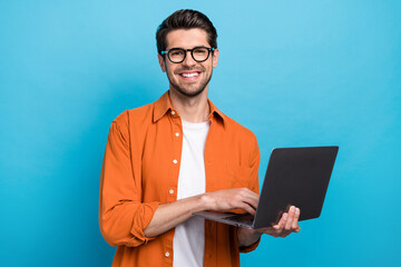 Fototapete - Photo of cheerful corporate agent man toothy smile hold use wireless netbook networking isolated on blue color background