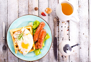 Poster - Delicious breakfast. Served on a wooden table with toast, eggs, sausage, wafers, juice. Top view. View from above