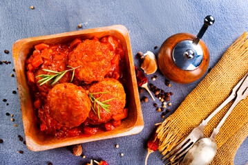 Wall Mural - hot meatballs with tomato sauce and basil close-up. top view