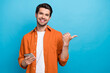 © deagreez - Photo of positive guy beaming smile hold use iphone apple gadget direct finger empty space isolated on blue color background