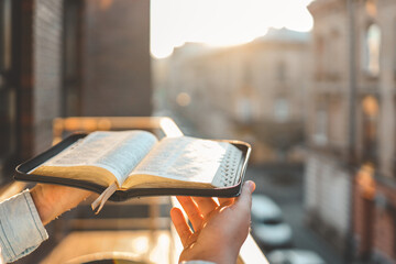 Wall Mural - Bible in hands at dawn on the street, morning reading