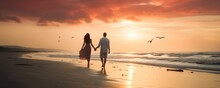 Couple Walking Along A Beach On A Romantic Evening