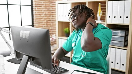 Wall Mural - African american man doctor using computer suffering for cervical pain at the clinic