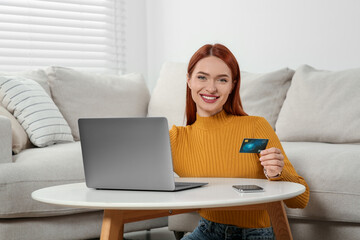 Wall Mural - Happy woman with credit card using laptop for online shopping at home